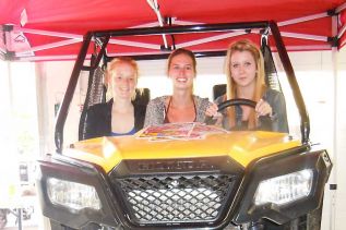 Volunteers at the Ompah Community Volunteer Associations annual Fall ATV Run l-r, Meagan Kirbyson, Vanessa Drury and volunteer fire fighter Haylee Hay pose on the 2015 Honda Pioneer that was raffled off at the run that took place on September 19